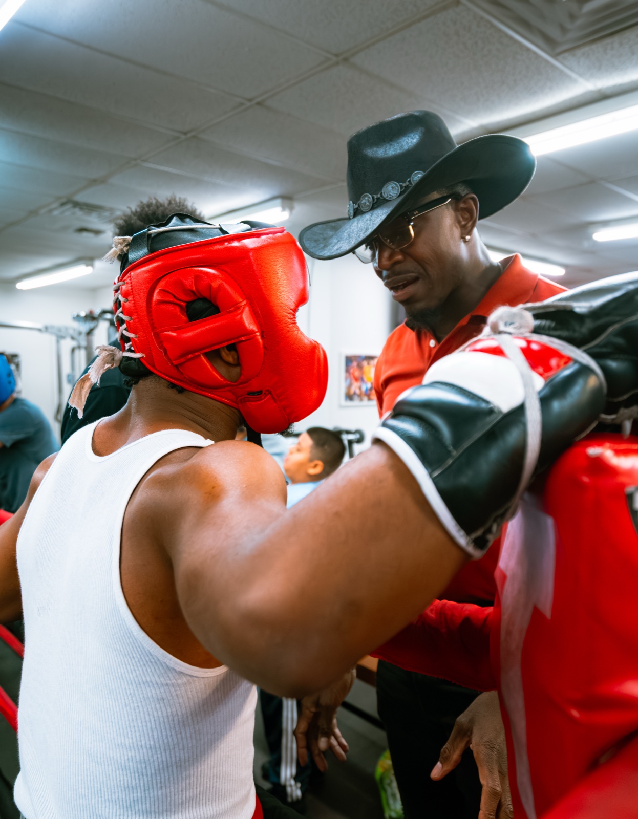 A Different Breed coach working headgear and mitts in the ring